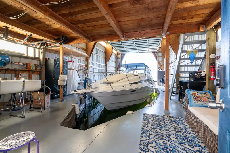 Slide: The Image of Interior of a 1970 custom boathouse with a docked boat and wooden beams. - 3