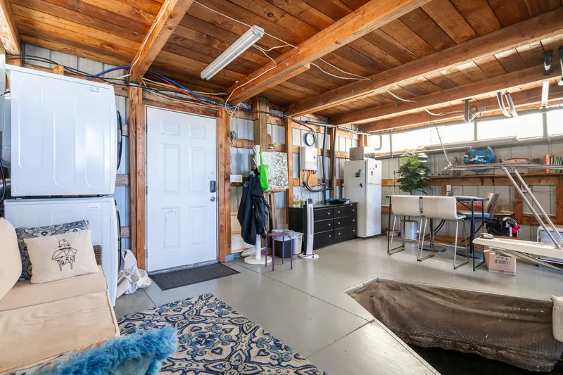 Slide: The Image of 1970 custom boathouse interior with wooden ceiling, modern appliances, and cozy seating area. - 4