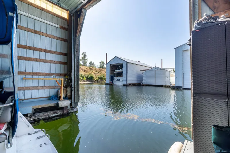 Slide: The Image of 1970 custom boathouse interior view with open water and adjacent structures. - 7