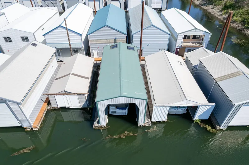 Slide: The Image of Aerial view of custom 1970 boathouses on water, featuring various roof designs. - 8