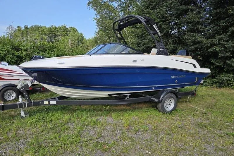 The Image of 2025 Bayliner VR5 OB boat on trailer, blue and white, parked outdoors. - 0