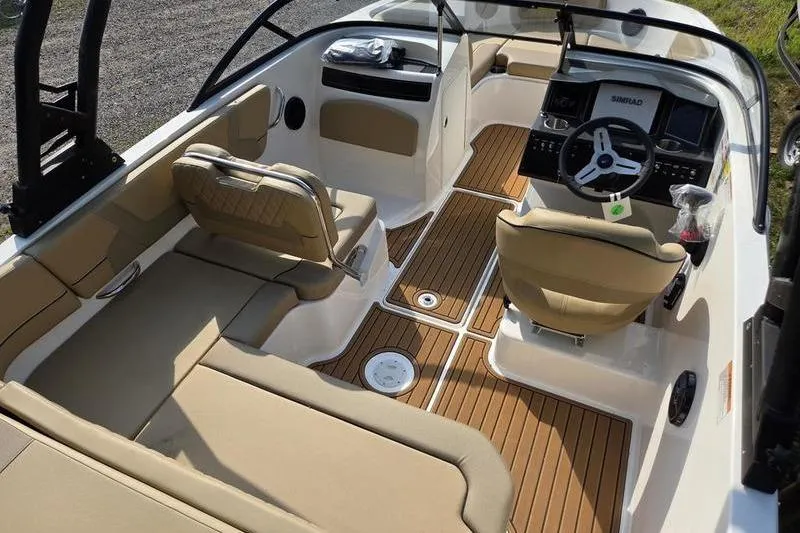 Slide: The Image of 2025 Bayliner VR5 OB boat interior with tan seating and wood-style flooring. - 11