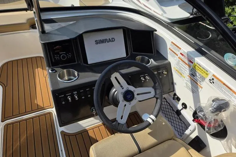 Slide: The Image of 2025 Bayliner VR5 OB boat cockpit with Simrad display and modern steering wheel. - 12