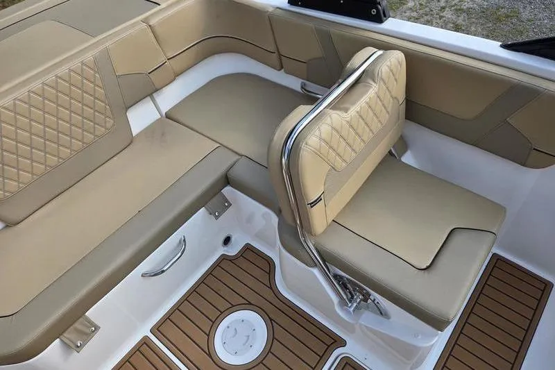 Slide: The Image of 2025 Bayliner VR5 OB boat interior with tan seating and wood-patterned flooring. - 2