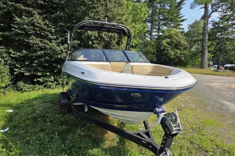 Slide: The Image of 2025 Bayliner VR5 OB boat on trailer, surrounded by lush greenery. - 6