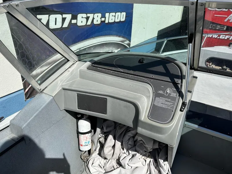 Slide: The Image of 2001 Smoker Craft 160 SP boat dashboard with windshield and fire extinguisher. - 12