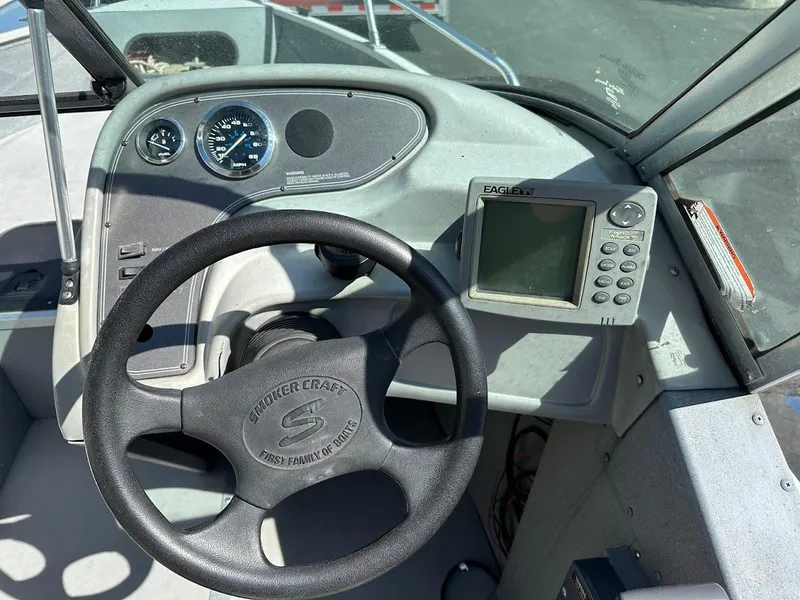 Slide: The Image of Dashboard of a 2001 Smoker Craft 160 SP boat with steering wheel and gauges. - 16