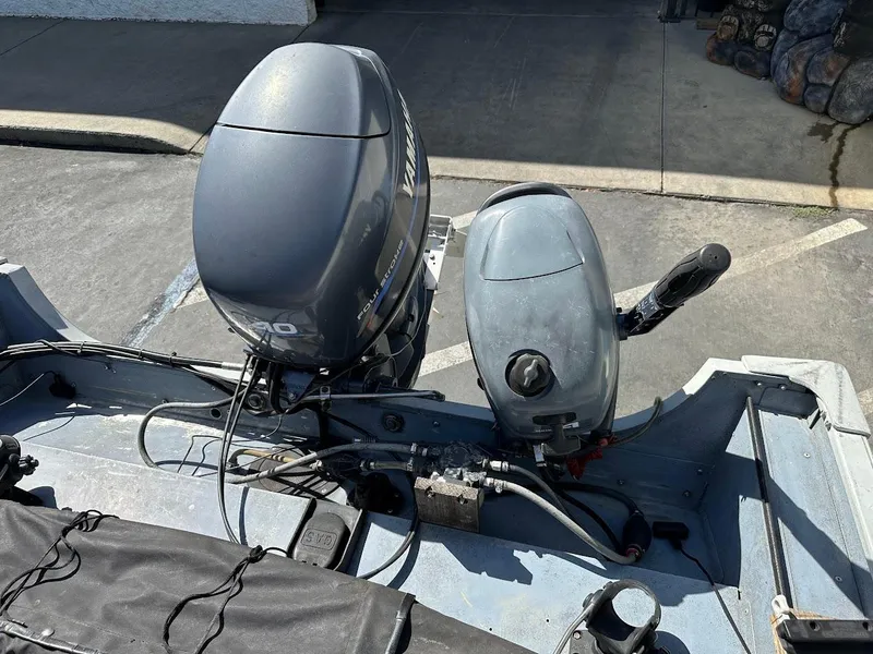 Slide: The Image of 2001 Smoker Craft 160 SP boat with dual outboard motors in a parking area. - 21