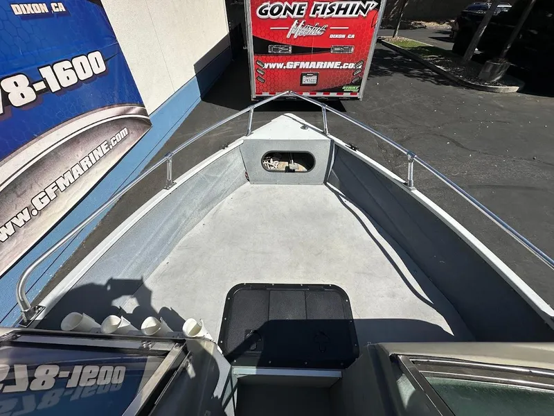 Slide: The Image of 2001 Smoker Craft 160 SP boat interior with fishing gear and trailer in background. - 24