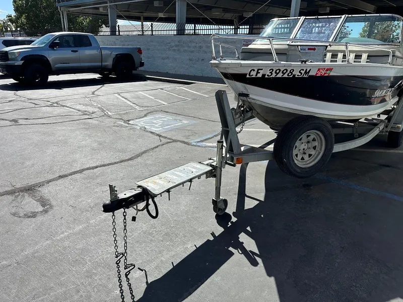 Slide: The Image of 2001 Smoker Craft 160 SP boat on trailer in parking lot, next to a silver truck. - 4