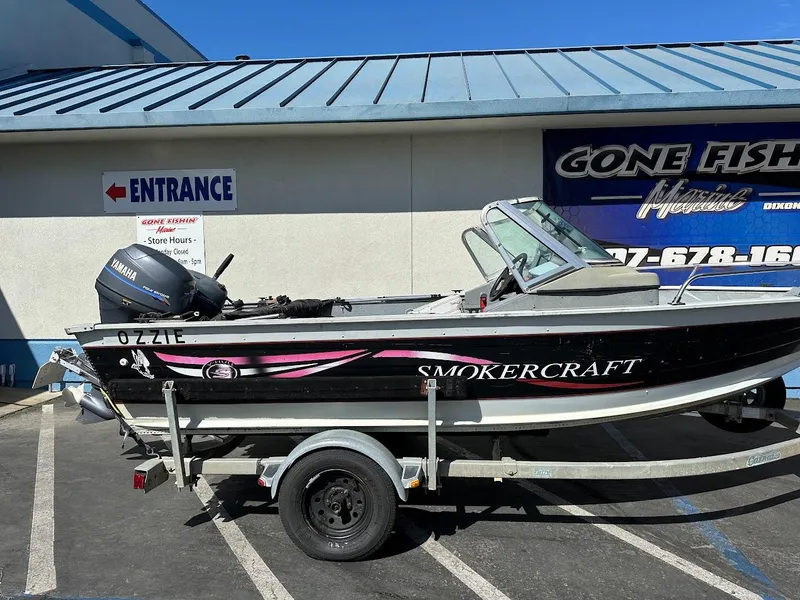 Slide: The Image of 2001 Smoker Craft 160 SP boat on trailer, parked outside a marine store. - 6