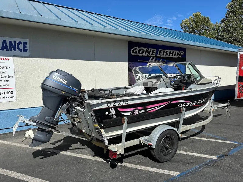Slide: The Image of 2001 Smoker Craft 160 SP boat on trailer with Yamaha outboard motor, parked outside. - 7