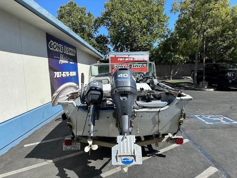 Slide: The Image of 2001 Smoker Craft 160 SP boat with dual outboard motors in a parking lot. - 8