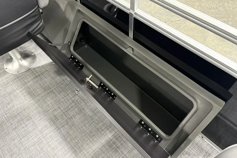 Slide: The Image of 2026 Sun Tracker SportFish™ 22 DLX storage compartment, open on a boat with gray flooring. - 14