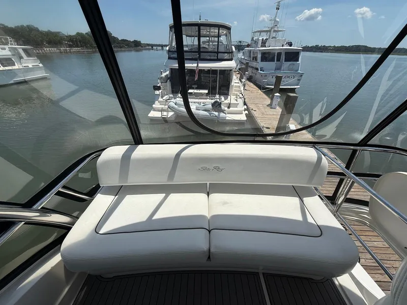 Slide: The Image of 2007 Sea Ray 52 Sedan Bridge interior with white seating, docked at marina. - 11
