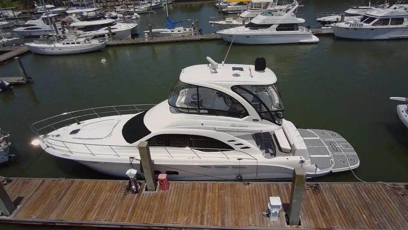Slide: The Image of 2007 Sea Ray 52 Sedan Bridge yacht docked at marina, surrounded by other boats. - 2