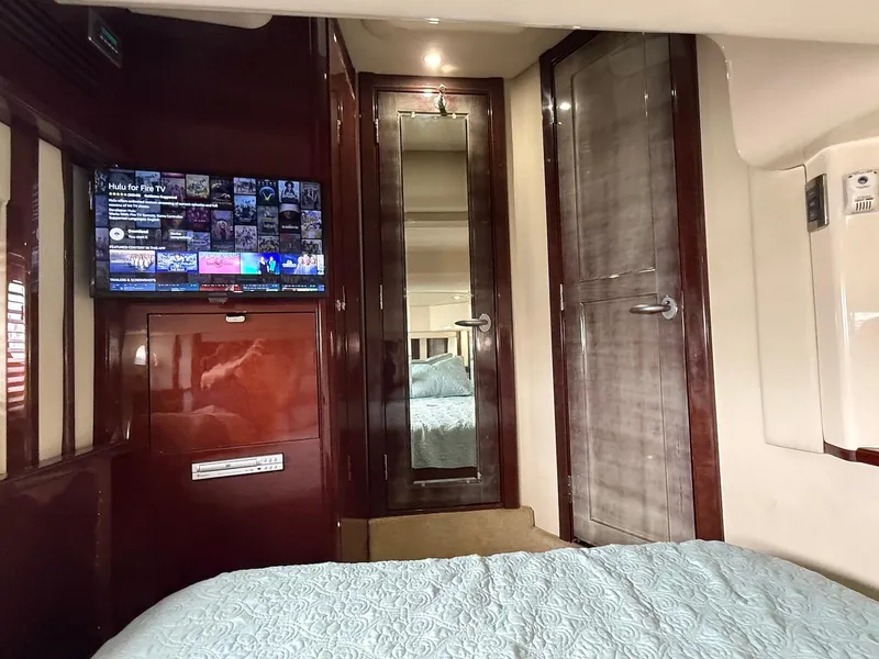 Slide: The Image of Interior of 2007 Sea Ray 52 Sedan Bridge with TV, mirror, and wooden cabinetry. - 37