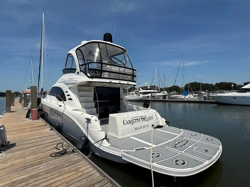 Slide: The Image of 2007 Sea Ray 52 Sedan Bridge yacht docked at marina under clear blue sky. - 6