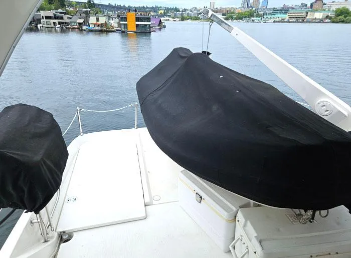 Slide: The Image of Bayliner 5288 Pilot House Motoryacht 2000, deck view with covered equipment, near waterfront. - 19