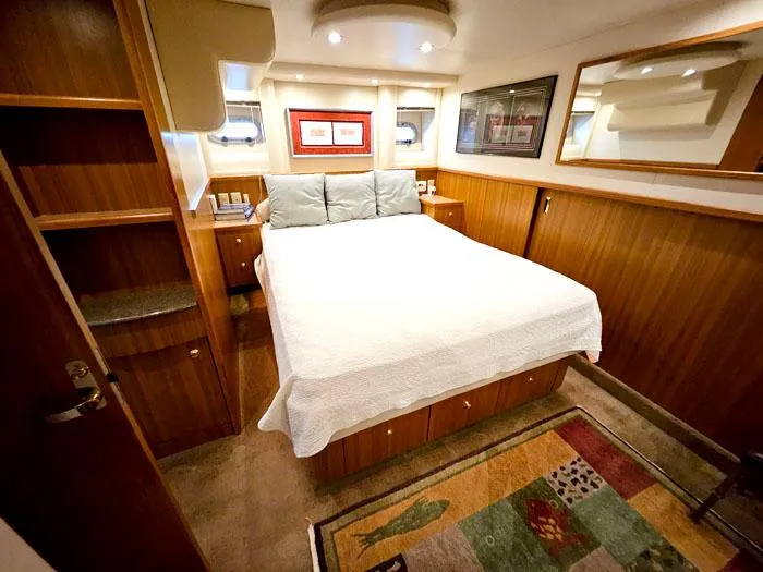 Slide: The Image of Luxurious bedroom interior of 2000 Bayliner 5288 Pilot House Motoryacht with cozy bed and wood paneling. - 23