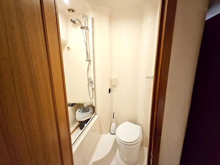 Slide: The Image of Compact bathroom in 2000 Bayliner 5288 Pilot House Motoryacht, featuring shower and toilet. - 26