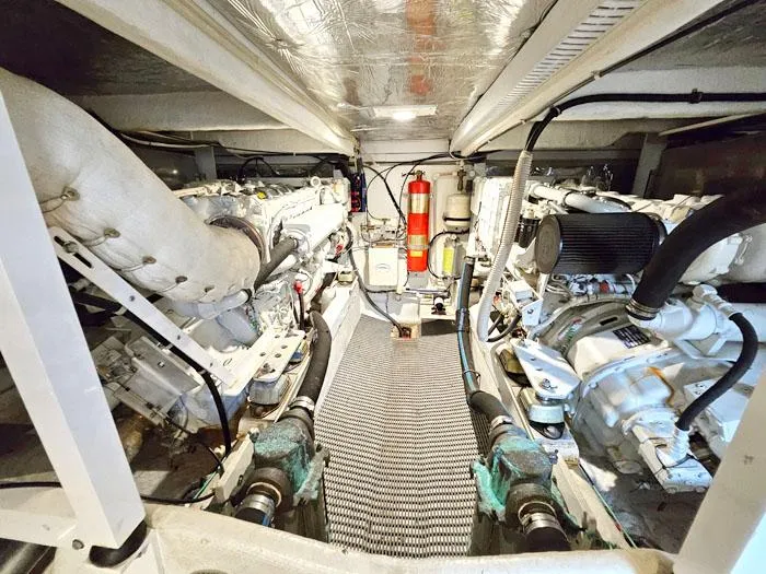 Slide: The Image of Engine room of 2000 Bayliner 5288 Pilot House Motoryacht, featuring dual engines and fire extinguisher. - 27