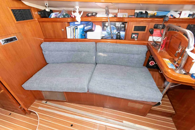 Slide: The Image of 2006 Hunter 44 Deck Salon interior with cushioned seating and wooden cabinetry. - 10