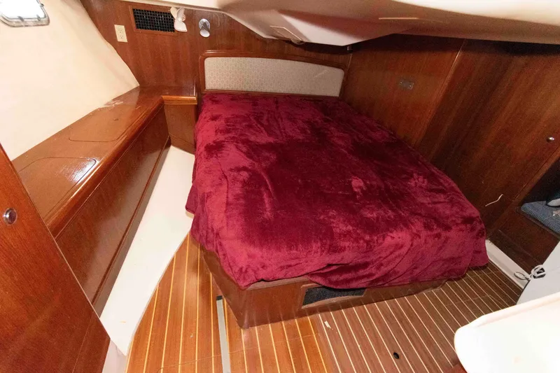 Slide: The Image of Cozy cabin interior of 2006 Hunter 44 Deck Salon with red bedding. - 13