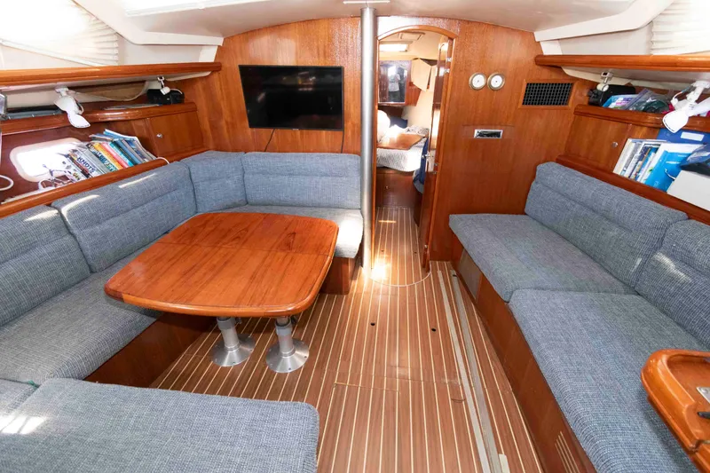 Slide: The Image of Interior of 2006 Hunter 44 Deck Salon with wood finishes and blue seating. - 7