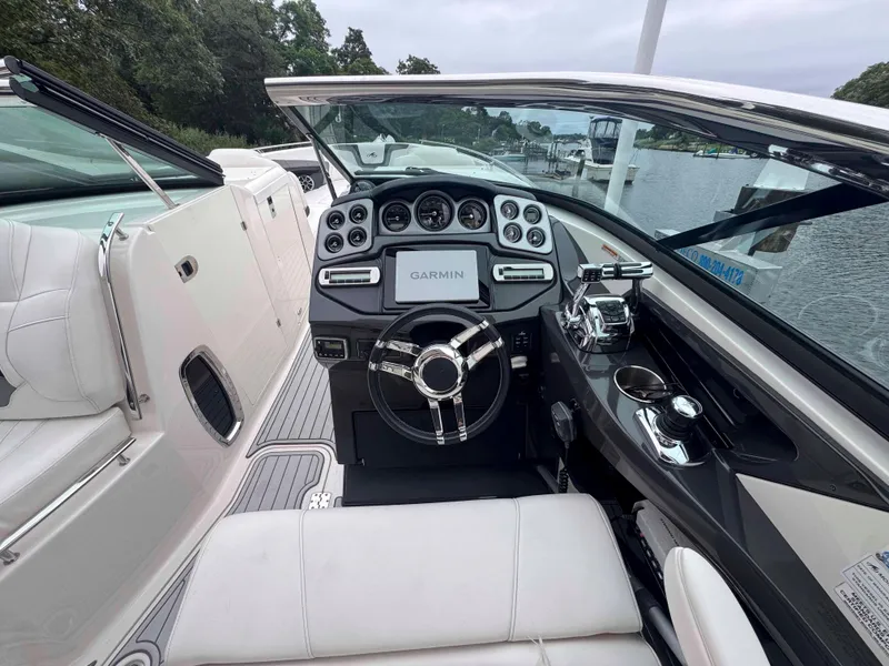 Slide: The Image of 2013 Monterey 328 Super Sport boat interior with Garmin navigation, sleek dashboard, and luxurious seating. - 13