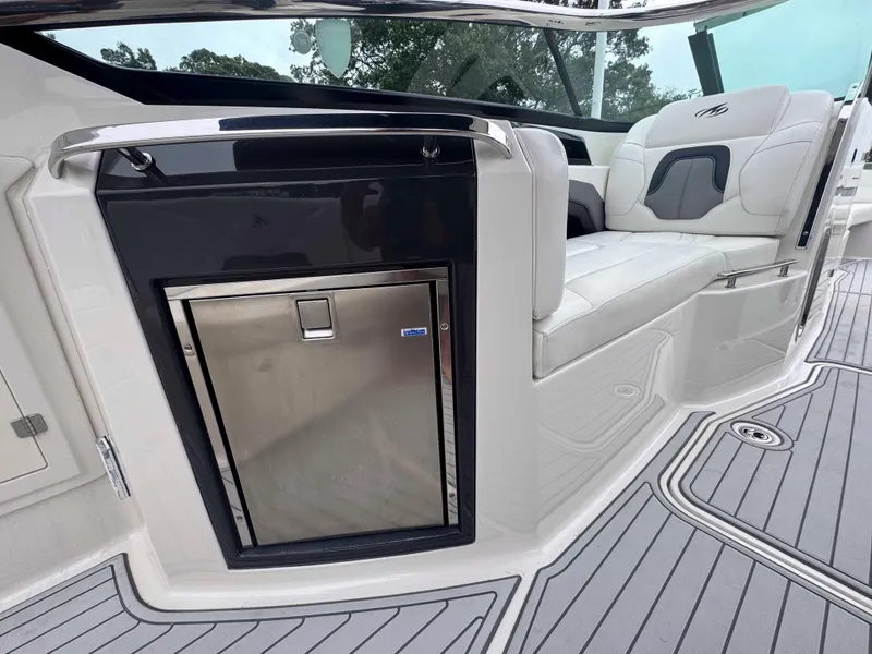 Slide: The Image of 2013 Monterey 328 Super Sport boat interior with seating and built-in refrigerator. - 16