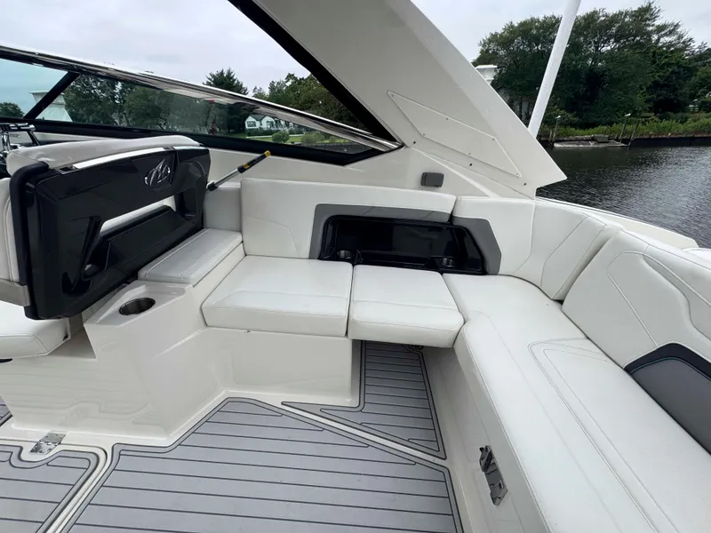Slide: The Image of 2013 Monterey 328 Super Sport boat interior with white seating and open storage compartment. - 17