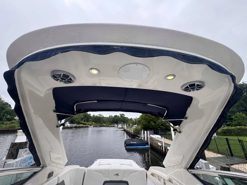 Slide: The Image of 2013 Monterey 328 Super Sport boat with canopy, docked by a serene riverside. - 21