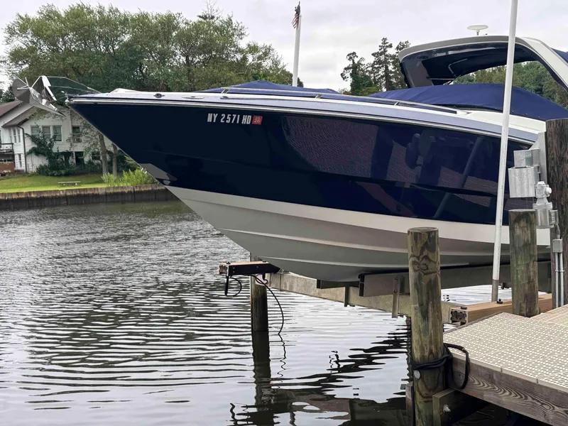 Slide: The Image of 2013 Monterey 328 Super Sport boat docked by a serene waterfront. - 3