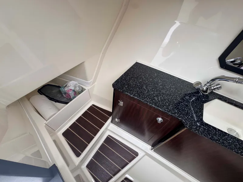 Slide: The Image of Interior of 2013 Monterey 328 Super Sport boat with sink, storage, and wooden flooring. - 33