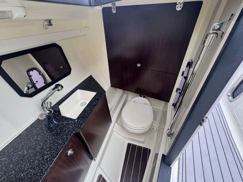 Slide: The Image of 2013 Monterey 328 Super Sport boat bathroom with sink, toilet, and dark wood accents. - 34
