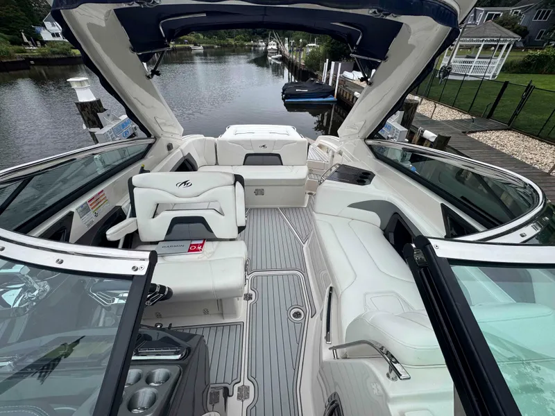 Slide: The Image of 2013 Monterey 328 Super Sport boat interior with white seating and open canopy. - 42