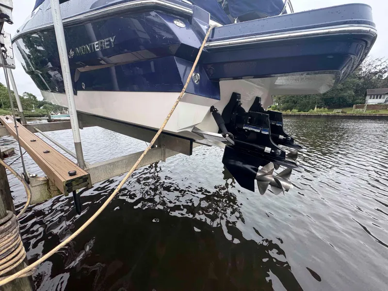 Slide: The Image of 2013 Monterey 328 Super Sport boat on lift, showcasing dual propellers above water. - 6