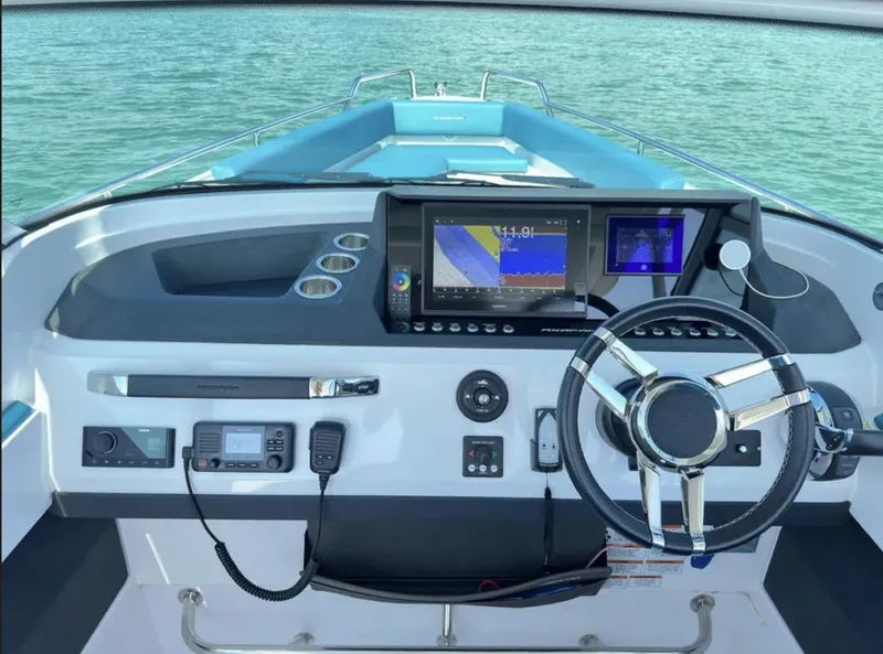 Slide: The Image of Cockpit of 2020 Axopar 28 TT boat with modern navigation equipment and steering wheel. - 15