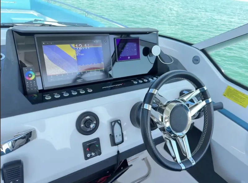 Slide: The Image of Control panel of 2020 Axopar 28 TT boat with steering wheel and navigation display. - 17