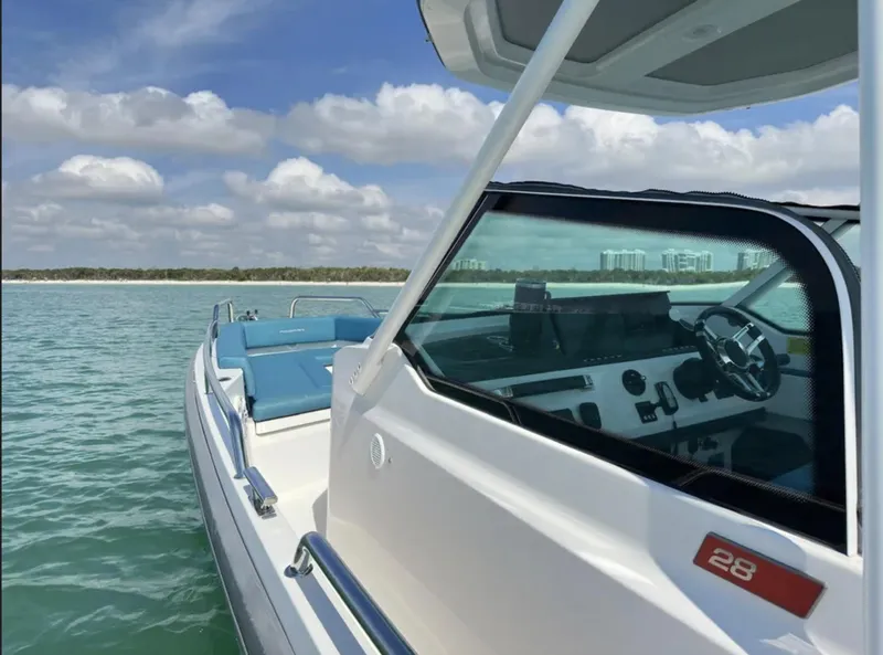 Slide: The Image of 2020 Axopar 28 TT boat on calm water with clear sky background. - 5