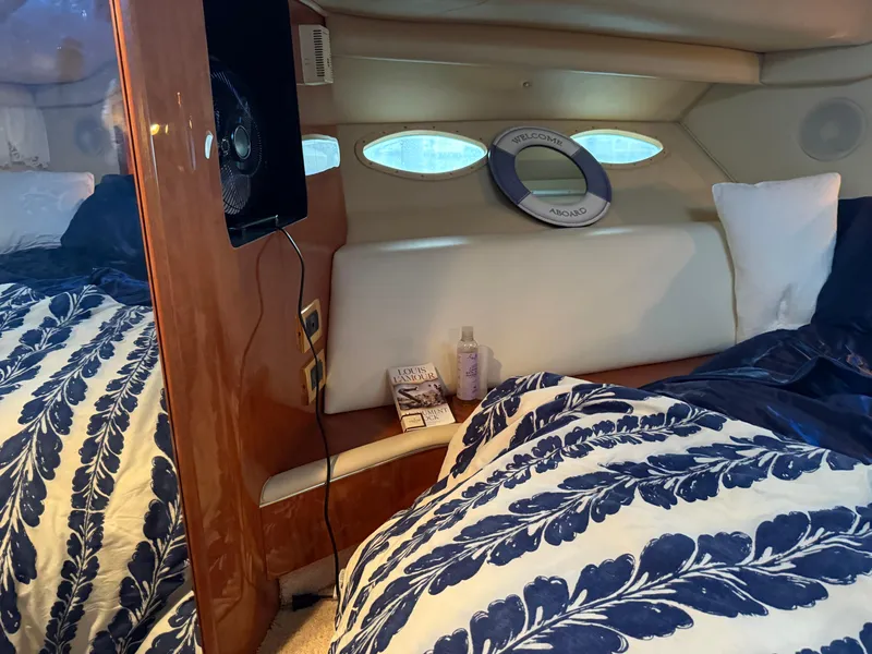 Slide: The Image of Cozy cabin interior of 1999 Sea Ray 400 Sedan Bridge with nautical decor and bedding. - 18