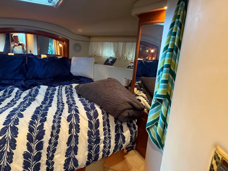 Slide: The Image of Cozy bedroom interior of 1999 Sea Ray 400 Sedan Bridge yacht with patterned bedding. - 19