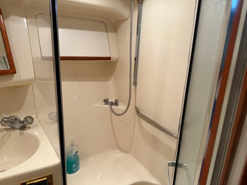 Slide: The Image of Bathroom interior of 1999 Sea Ray 400 Sedan Bridge yacht, featuring shower and sink. - 21