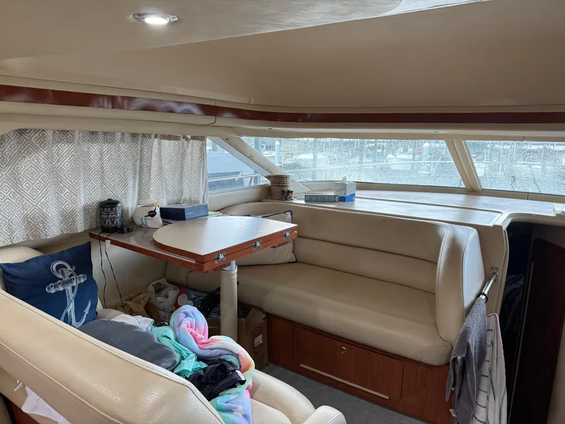 Slide: The Image of Interior of 1999 Sea Ray 400 Sedan Bridge with beige seating and table. - 29