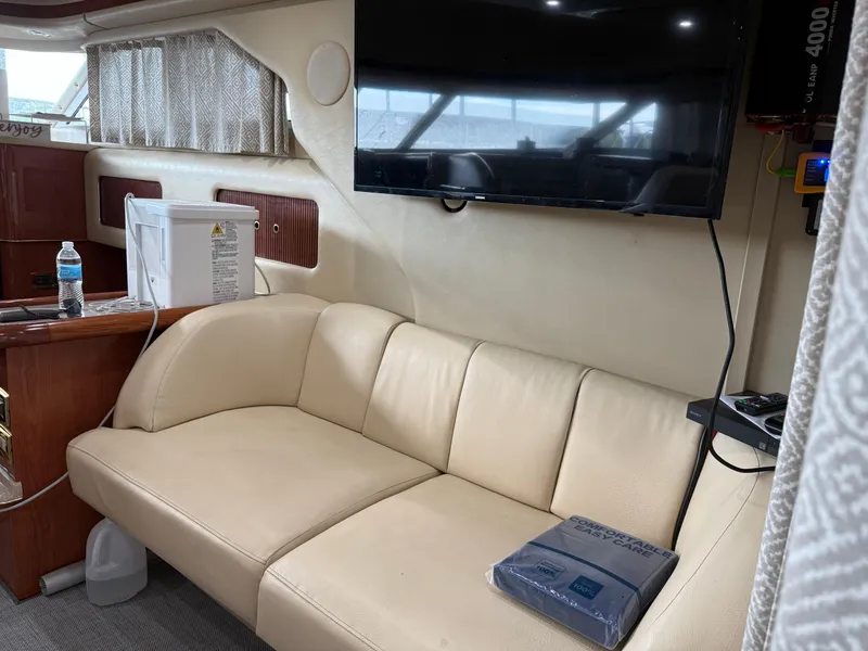 Slide: The Image of Interior of 1999 Sea Ray 400 Sedan Bridge with beige sofa and mounted TV. - 33
