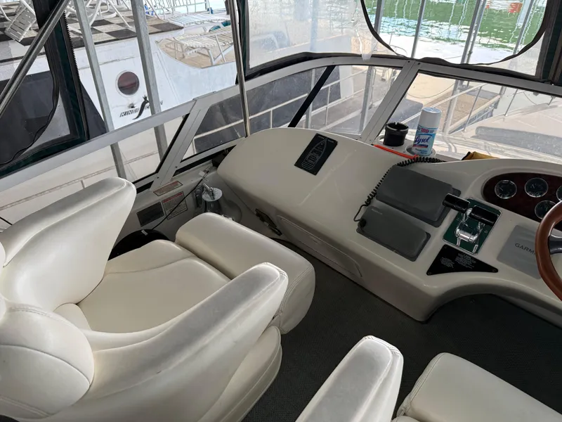 Slide: The Image of Interior of a 1999 Sea Ray 400 Sedan Bridge yacht cockpit with white seating and control panel. - 38