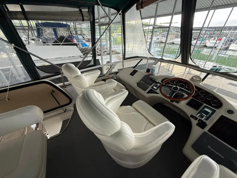 Slide: The Image of Interior of 1999 Sea Ray 400 Sedan Bridge yacht with white leather seats and control panel. - 39