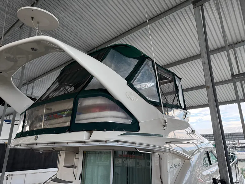 Slide: The Image of 1999 Sea Ray 400 Sedan Bridge yacht in covered dock, featuring enclosed flybridge. - 4