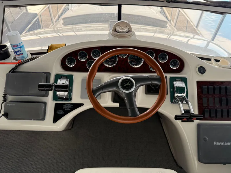 Slide: The Image of 1999 Sea Ray 400 Sedan Bridge helm with gauges, steering wheel, and controls. - 41